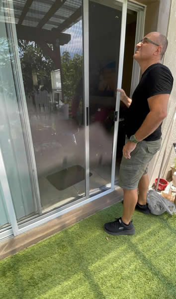 Lanai Paradise Technician Performing an onsite inspection of a sliding glass door at a home residence